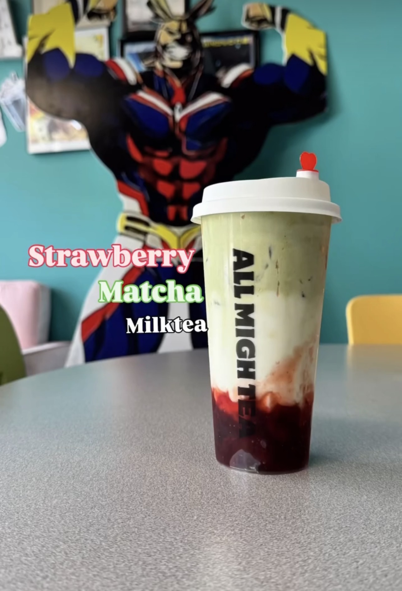 Strawberry matcha milk tea in front of All Might decor