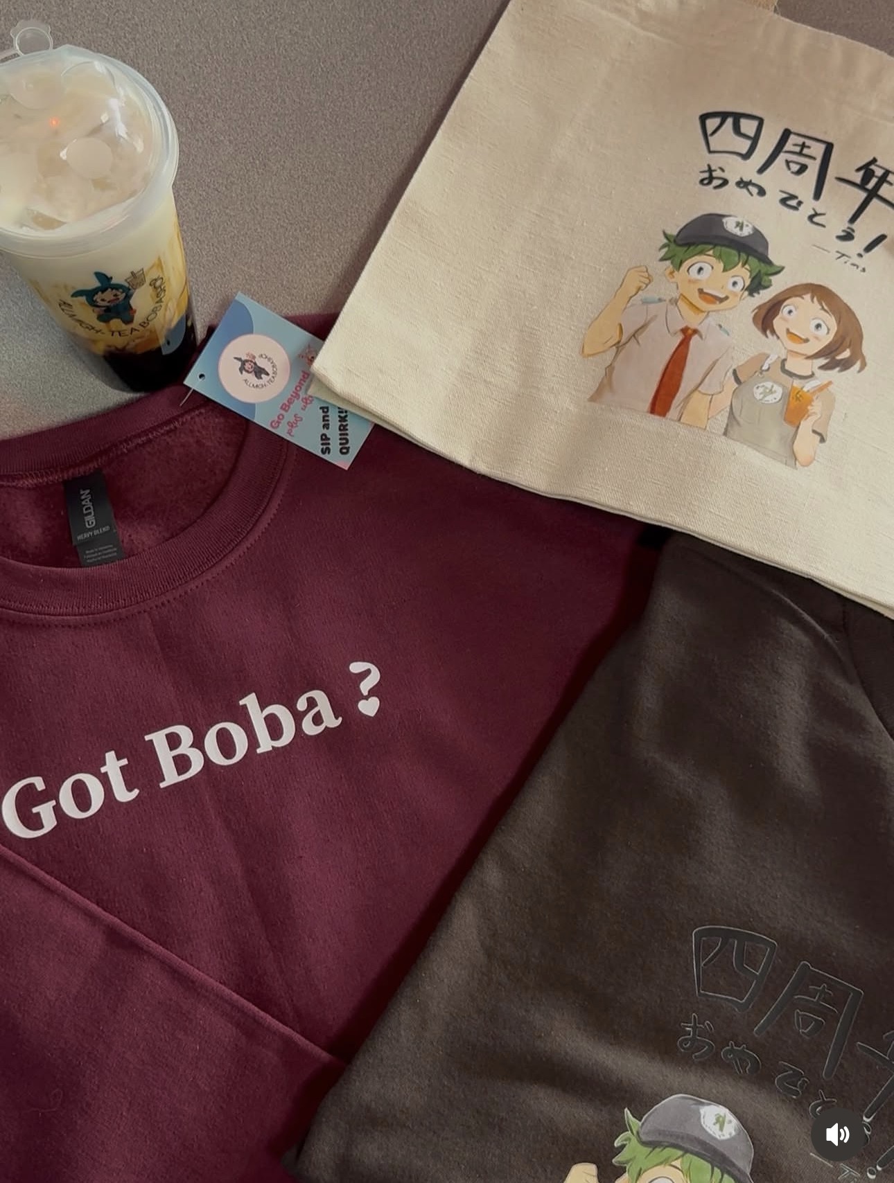 All Migh-Tea shirts, tote bag, and boba drink flat lay